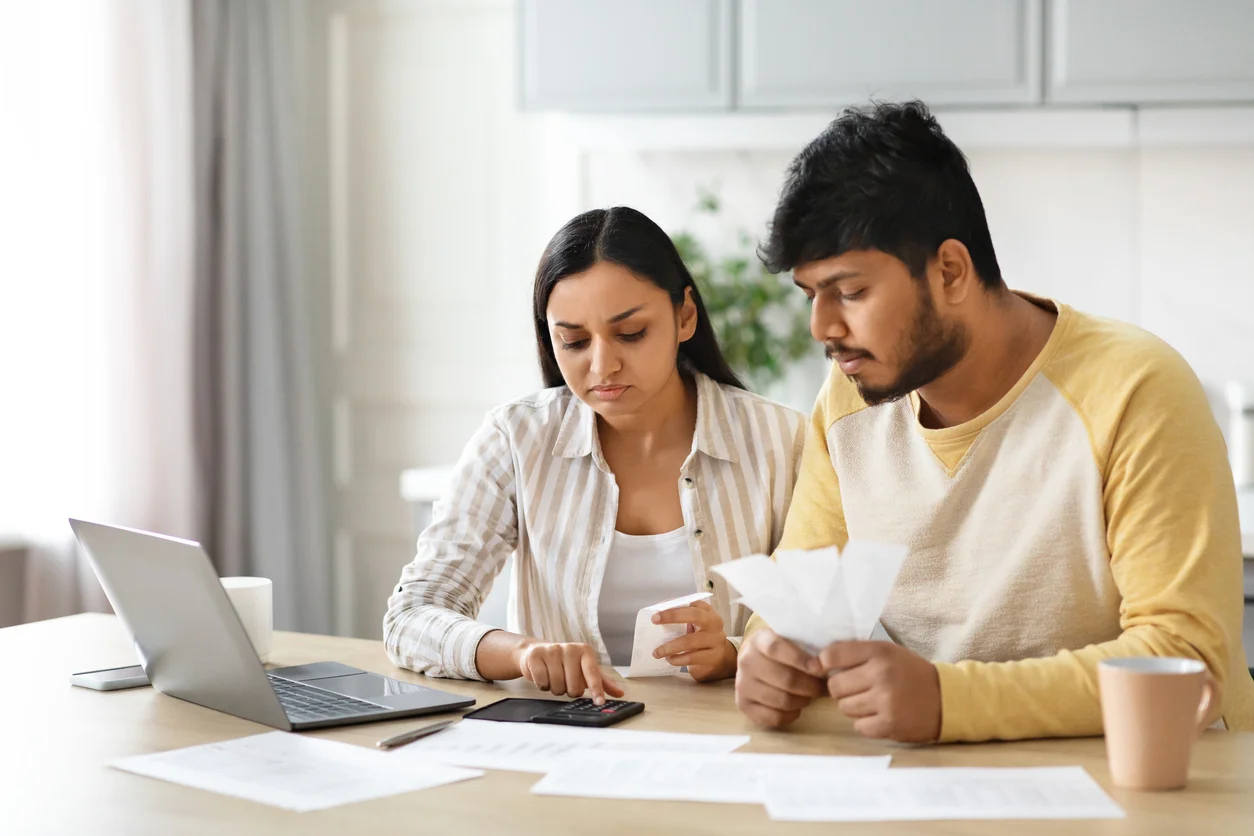 two people looking at a computer and insurance paperwork